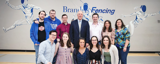 A group of people pose with fencing coach Bill Shipman